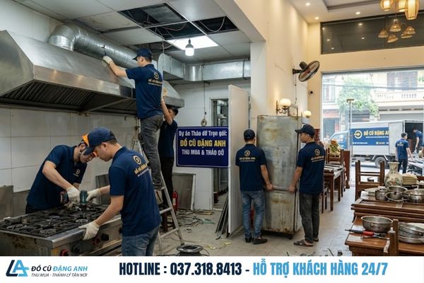 Đội ngũ Đồ Cũ Đặng Anh mặc đồng phục xanh đậm đang tháo dỡ thiết bị trong nhà hàng
